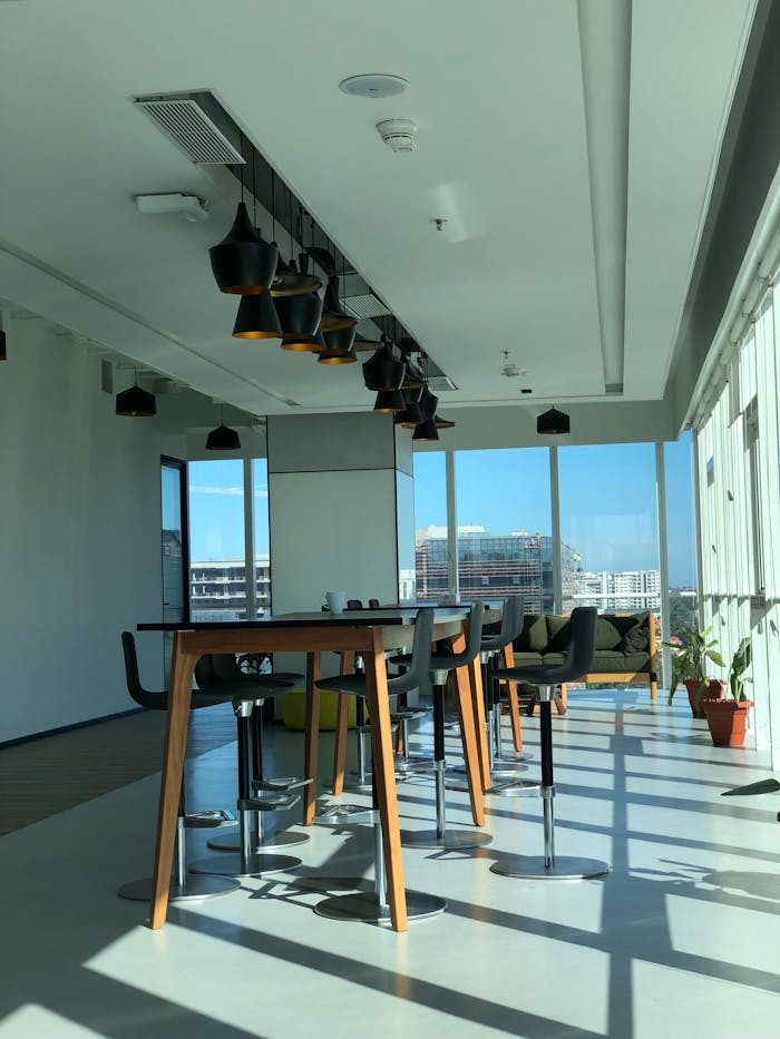 services-02 Spacious sunlit office interior featuring contemporary furniture and large windows.